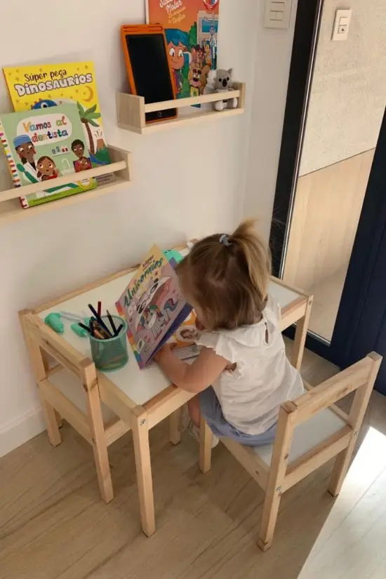 Niña pequeña pintando en una mesa en el rincón infantil de la clínica